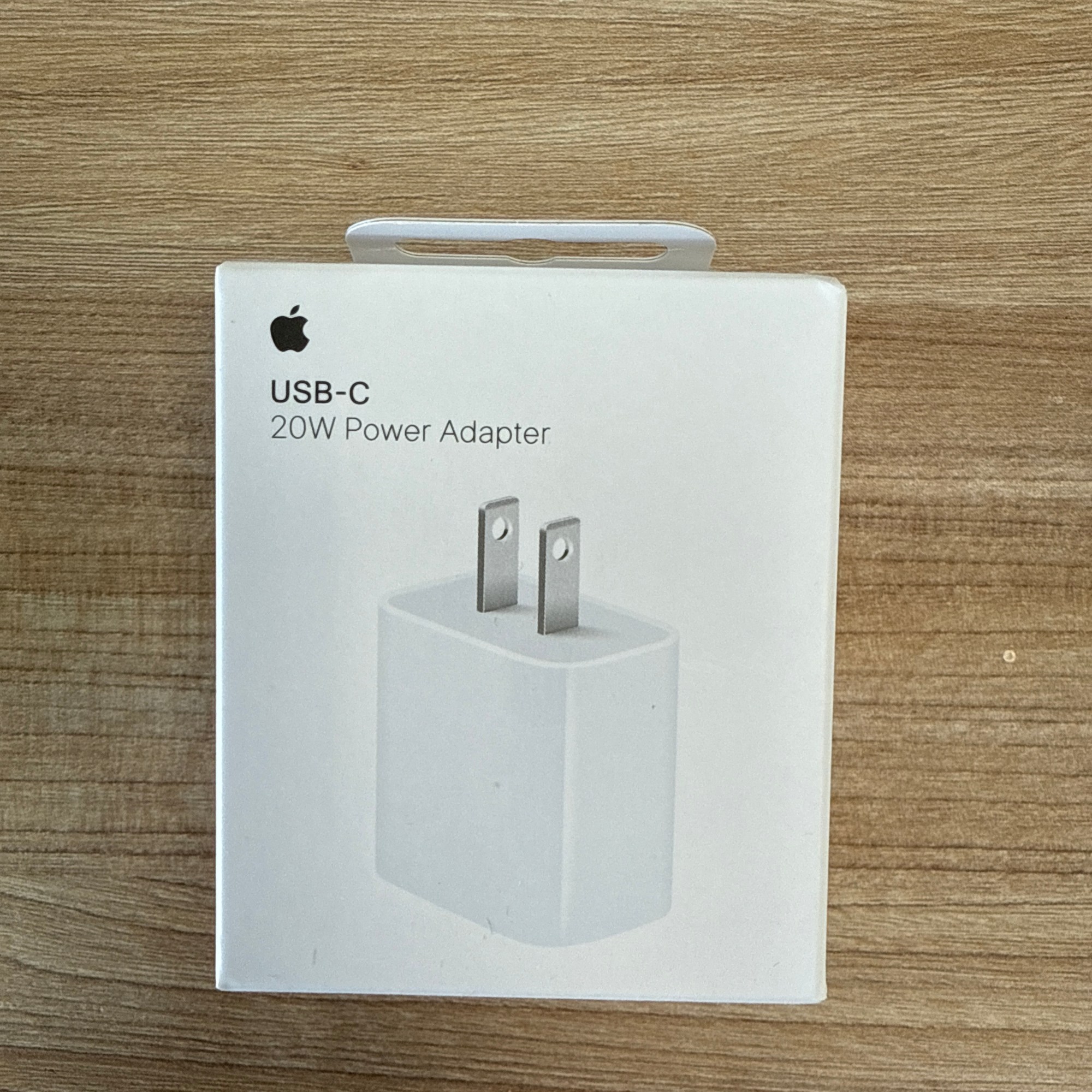 “Apple USB-C 20W power adapter in white retail packaging.”